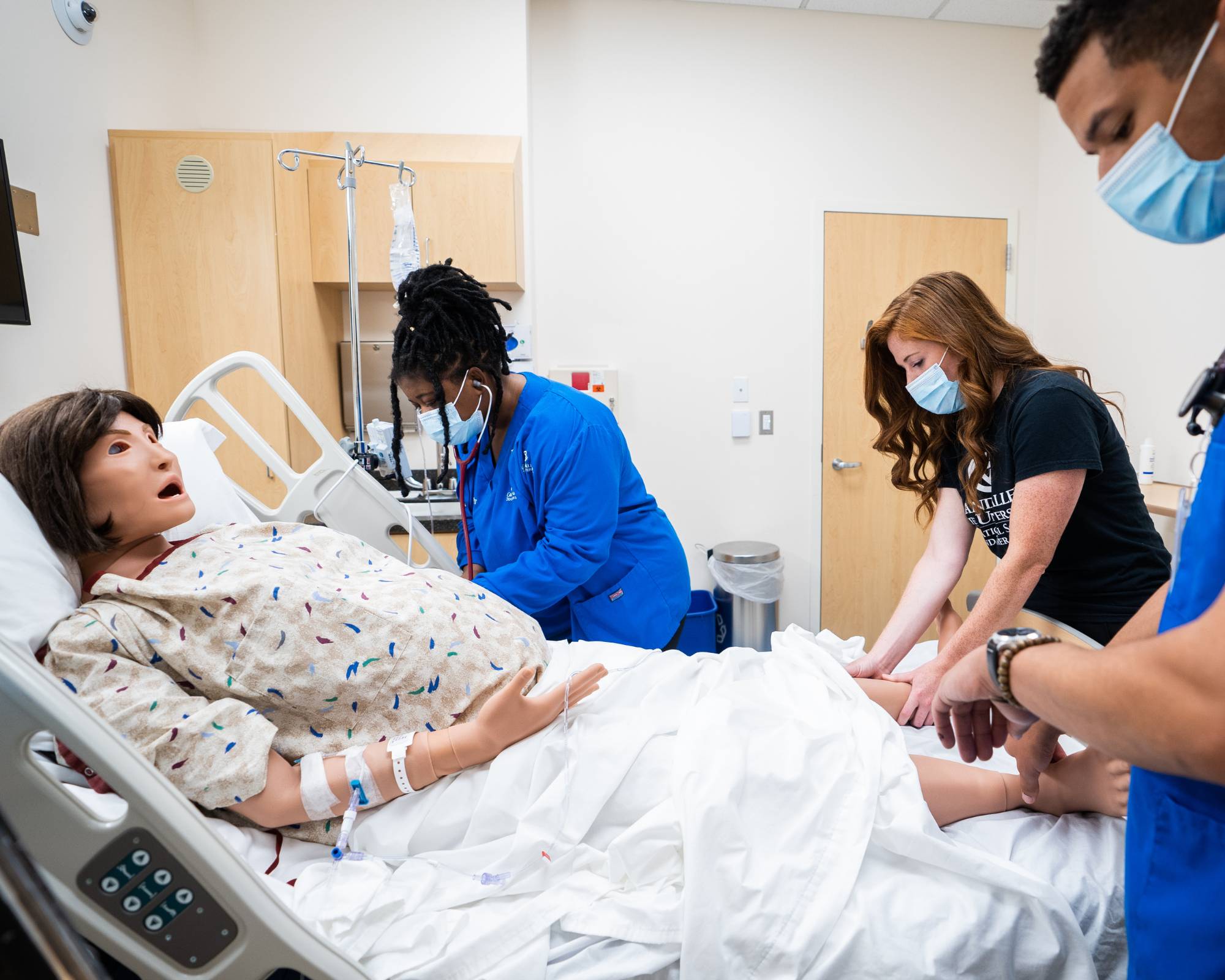 Medical students work with a patient simulation